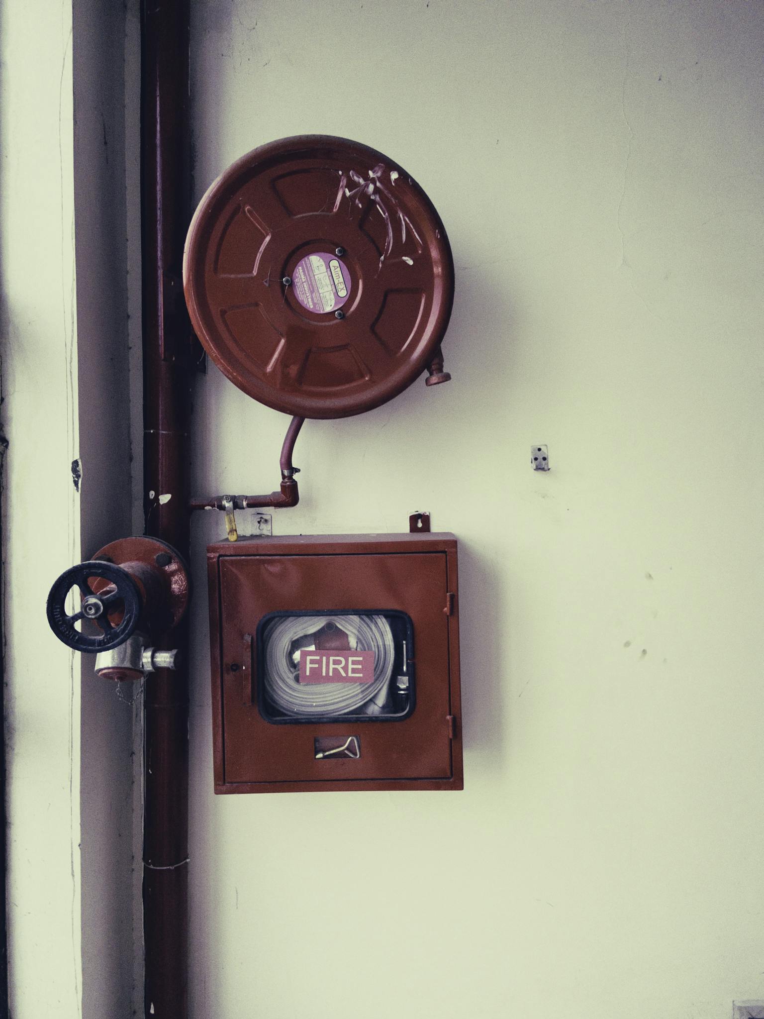 Red fire safety equipment on a white wall, essential for emergencies.